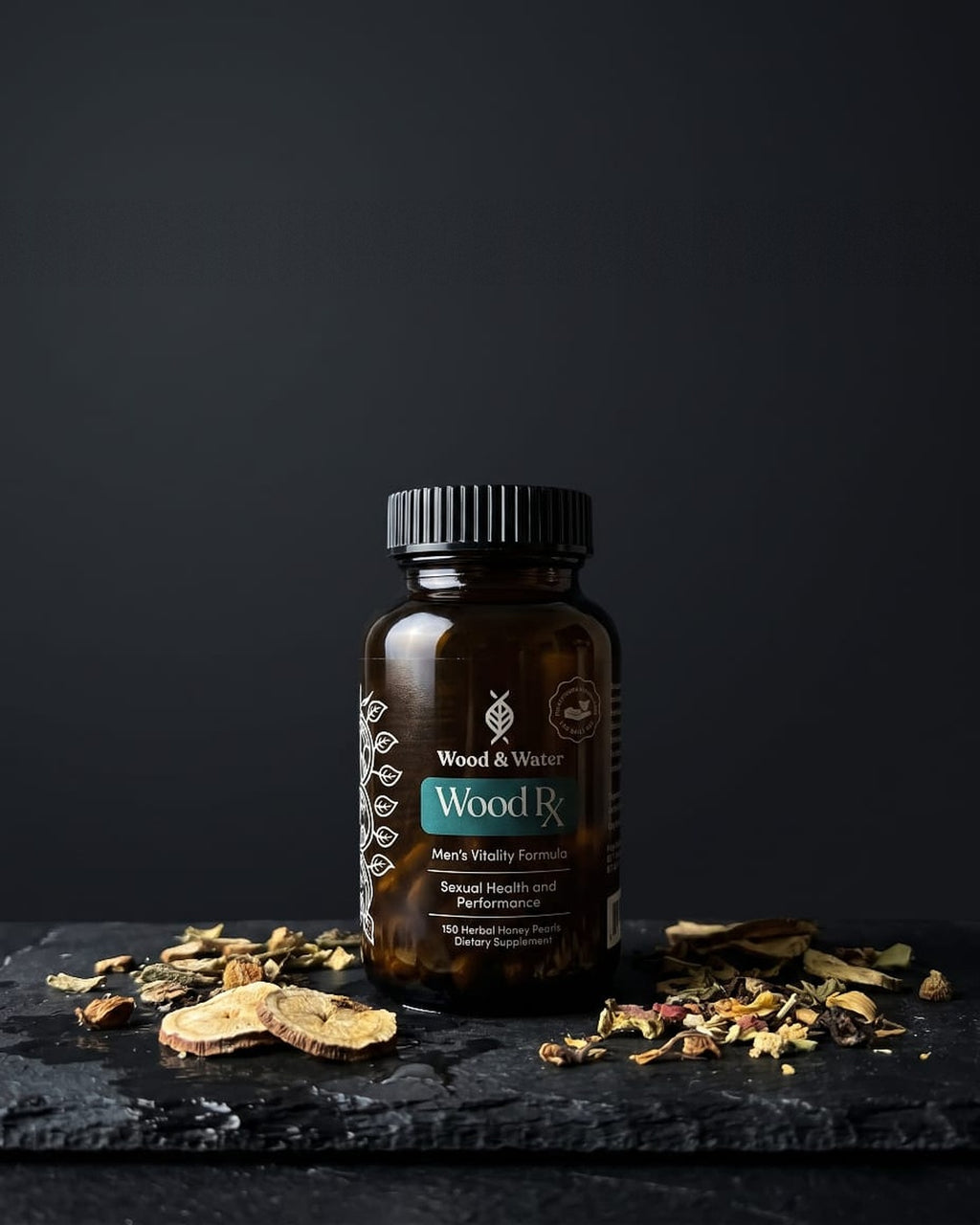 Wood Rx men's vitality formula — amber glass bottle with dried Chinese herbs on dark slate